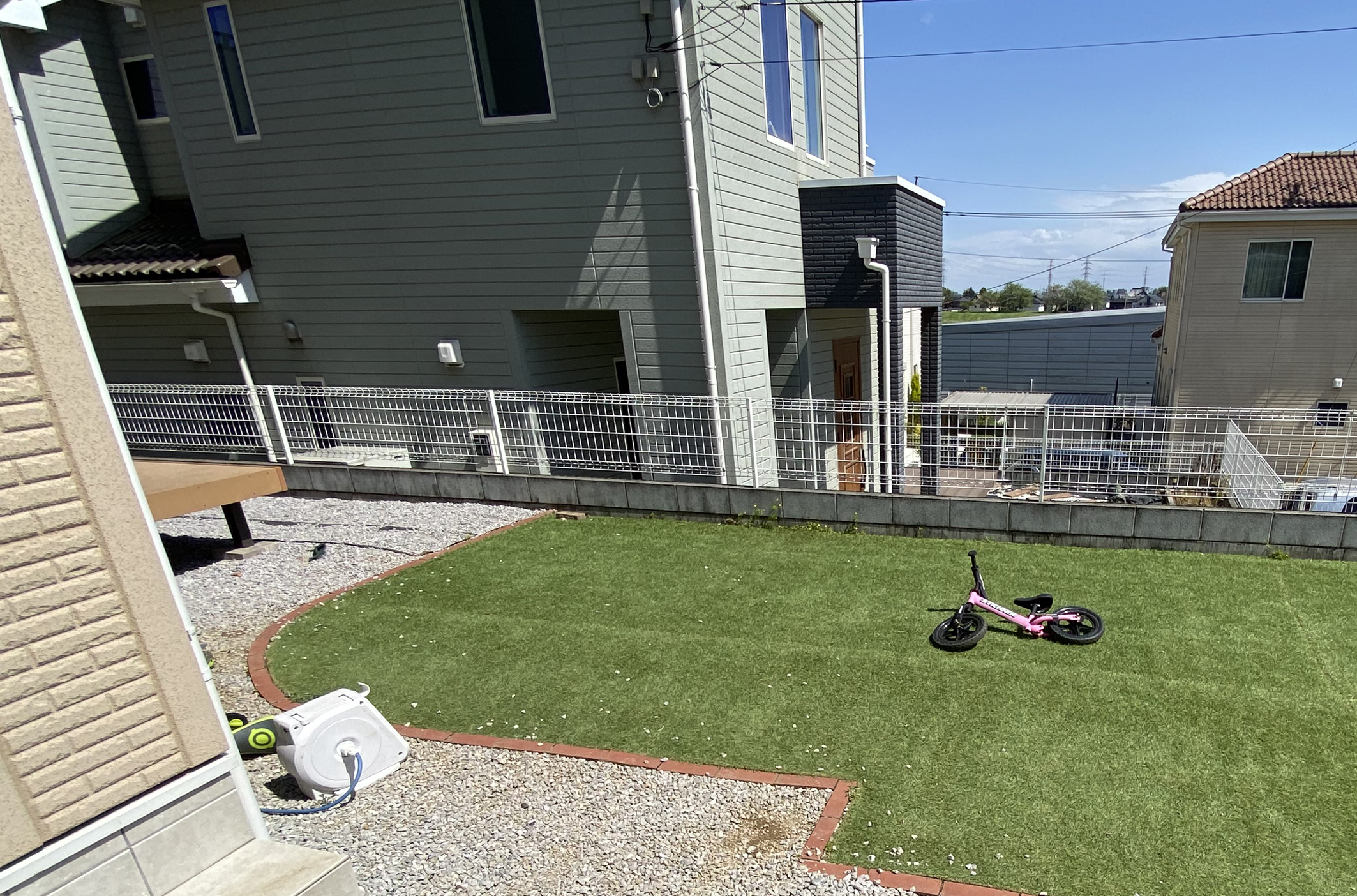 施工前のお庭の様子。お施主さまがレンガで囲いをつくり、その中に人工芝が敷いてあります。